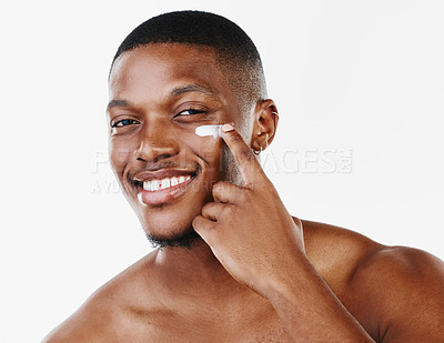 Buy stock photo Studio portrait of a handsome young man applying moisturiser against a white background