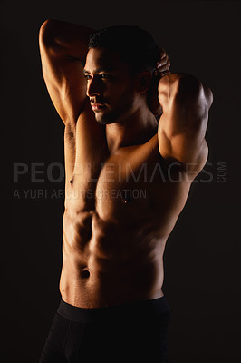 Buy stock photo Studio shot of a fit young man posing against a black background
