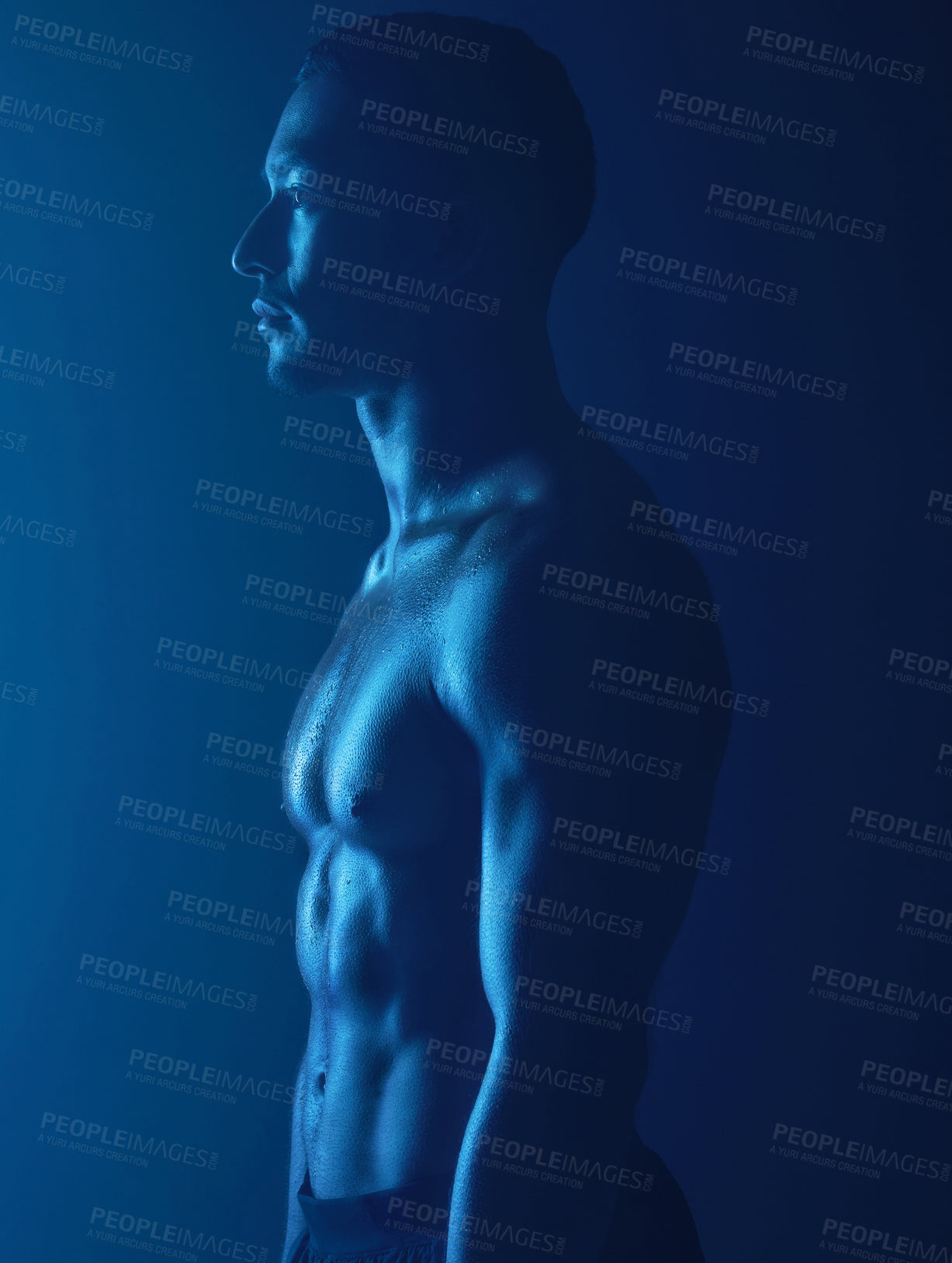 Buy stock photo Studio shot of a fit young man posing against a dark background