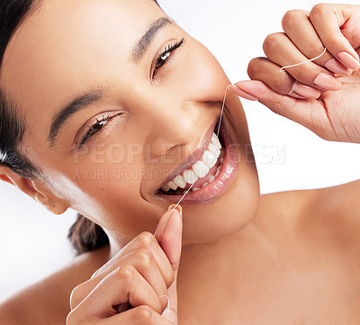 Buy stock photo Studio portrait of a beautiful young woman flossing her teeth against a white background
