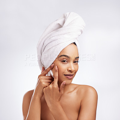 Buy stock photo Studio portrait of a beautiful young woman squeezing a pimple on her face against a white background