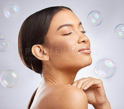 Buy stock photo Studio shot of an attractive young woman posing against a grey background with bubbles