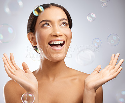 Buy stock photo Studio shot of an attractive young woman posing against a grey background with bubbles