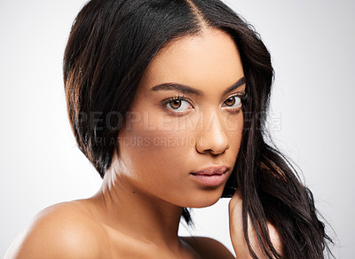 Buy stock photo Cropped portrait of an attractive young woman posing in studio against a grey background