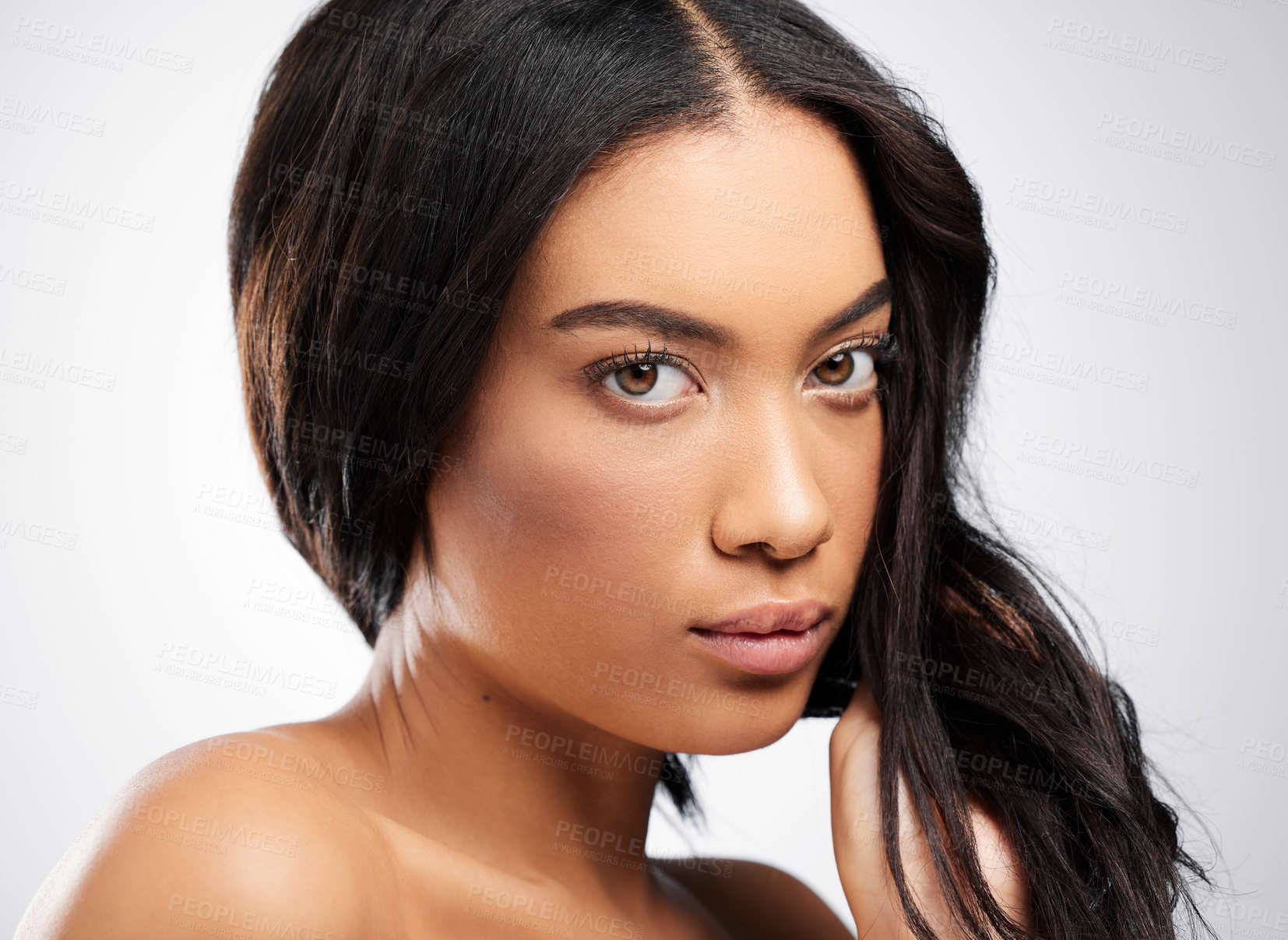 Buy stock photo Cropped portrait of an attractive young woman posing in studio against a grey background