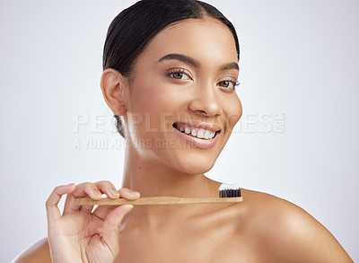 Buy stock photo Studio shot of an attractive young woman brushing her teeth against a grey background