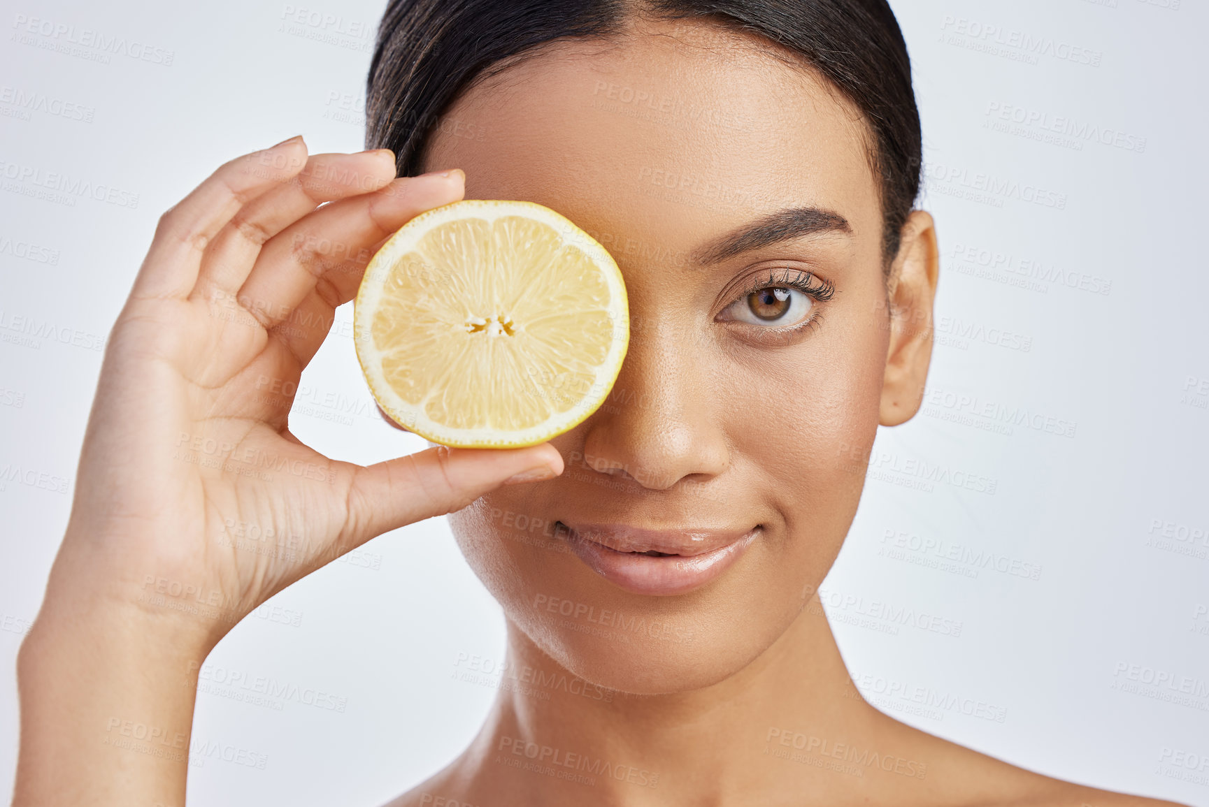 Buy stock photo Studio shot of an attractive young woman holding a lemon against a grey background