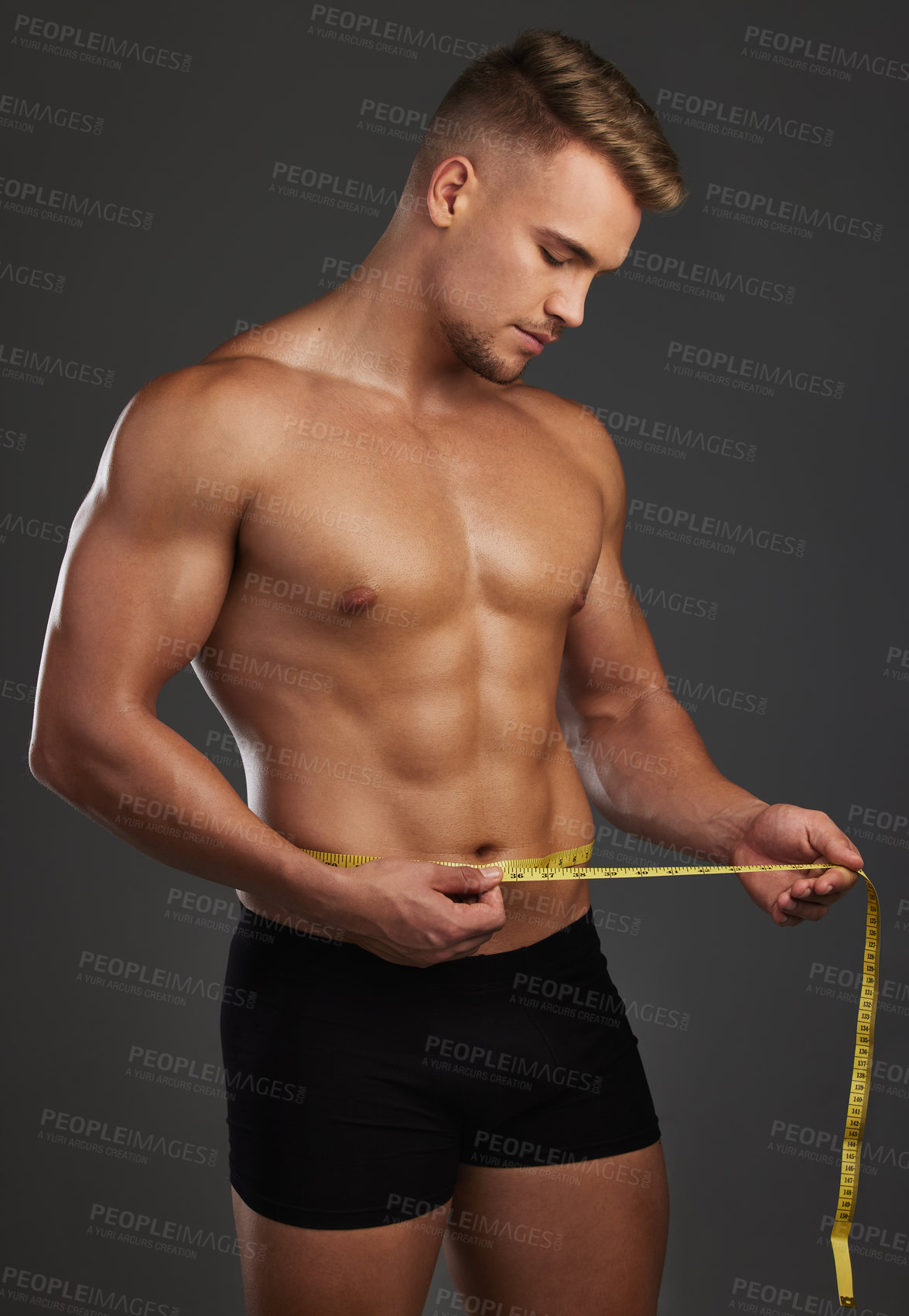 Buy stock photo Fitness, stomach and man in studio with measuring tape for bodybuilding abs, goals and progress on black background. Muscle, body and male athlete with sixpack measurement, growth or bmi tracking