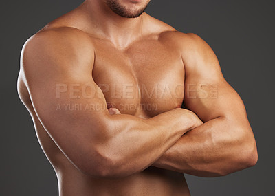 Buy stock photo Closeup shot of an unrecognizable and athletic young man's chest while he poses arms folded in studio against a dark background