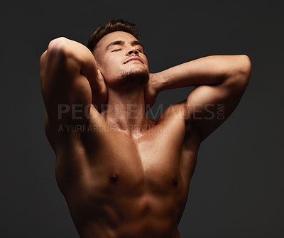 Buy stock photo Cropped shot of a handsome and athletic young man posing shirtless in studio against a dark background