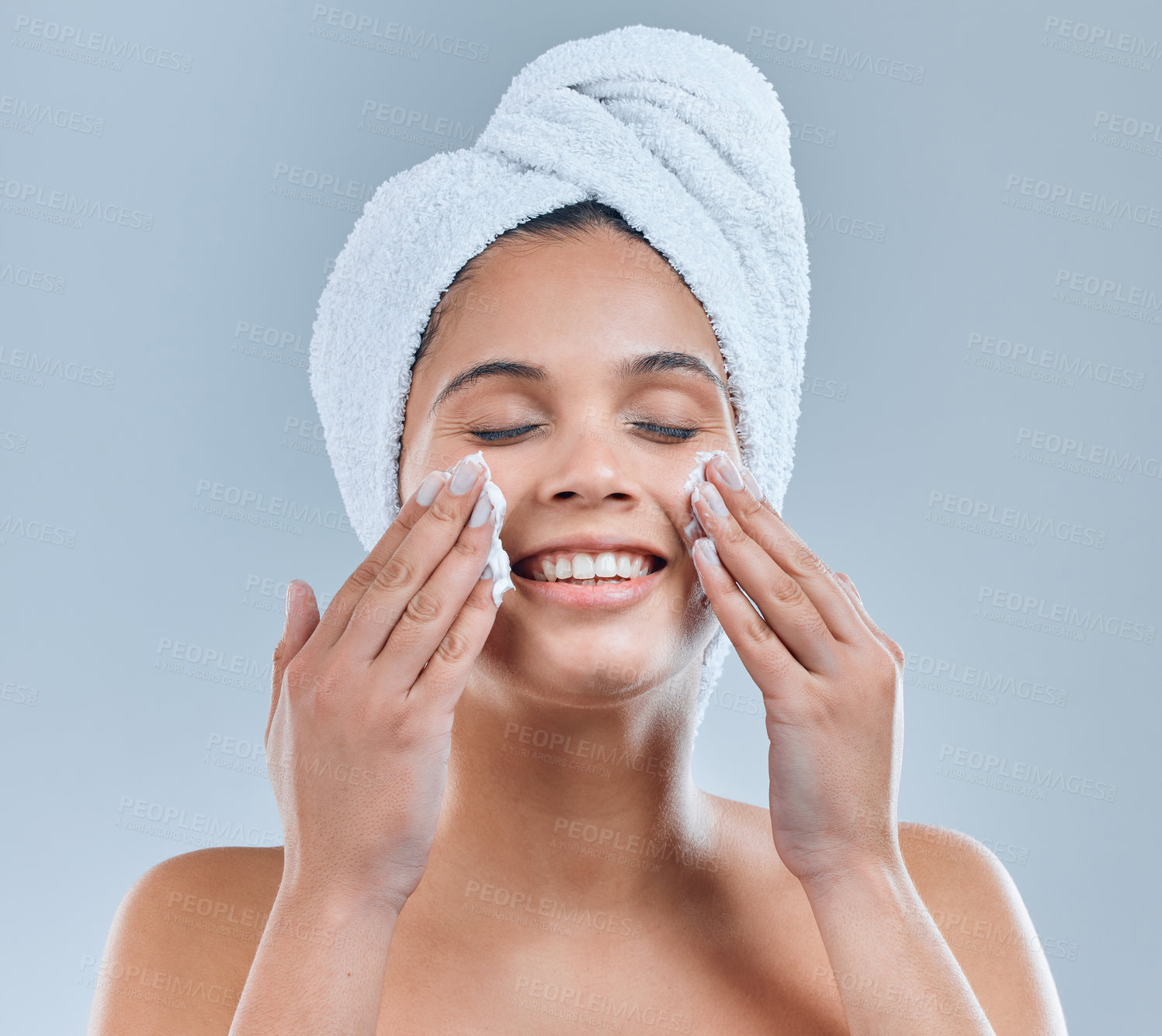 Buy stock photo Shot of a young woman washing her face in the shower against a grey background