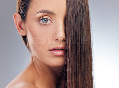 Buy stock photo Shot of an attractive young woman standing alone in the studio and posing