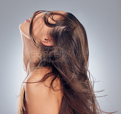 Buy stock photo Shot of a young woman standing alone in the studio and posing with her hair covering half of her face
