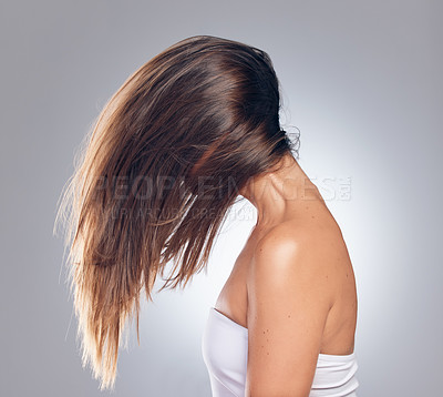 Buy stock photo Shot of an unrecognizable woman standing alone in the studio and flipping her hair