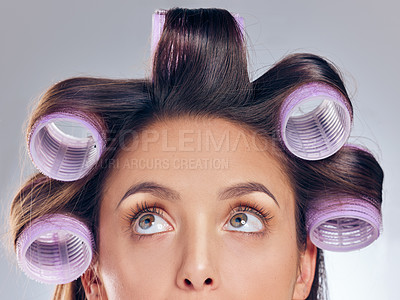 Buy stock photo Cropped shot of an attractive young woman standing alone in the studio and posing with rollers in her hair
