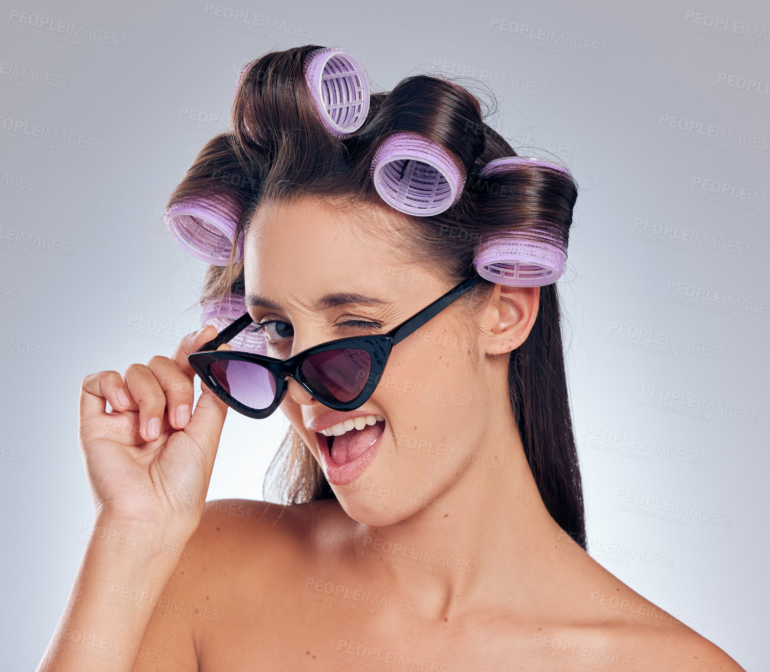 Buy stock photo Woman, portrait and sunglasses in hair roller set, hairstyle by white background and happy. Face, model haircare and curlers for cosmetics, beauty salon treatment and makeup with wink in studio