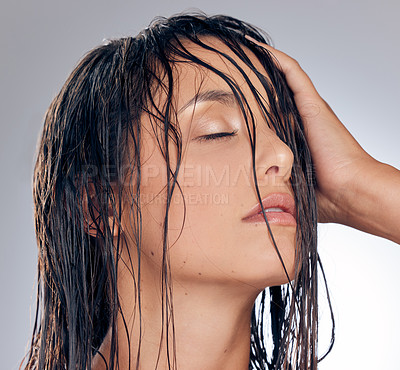Buy stock photo Shot of an attractive young woman standing alone in the studio and posing with wet hair