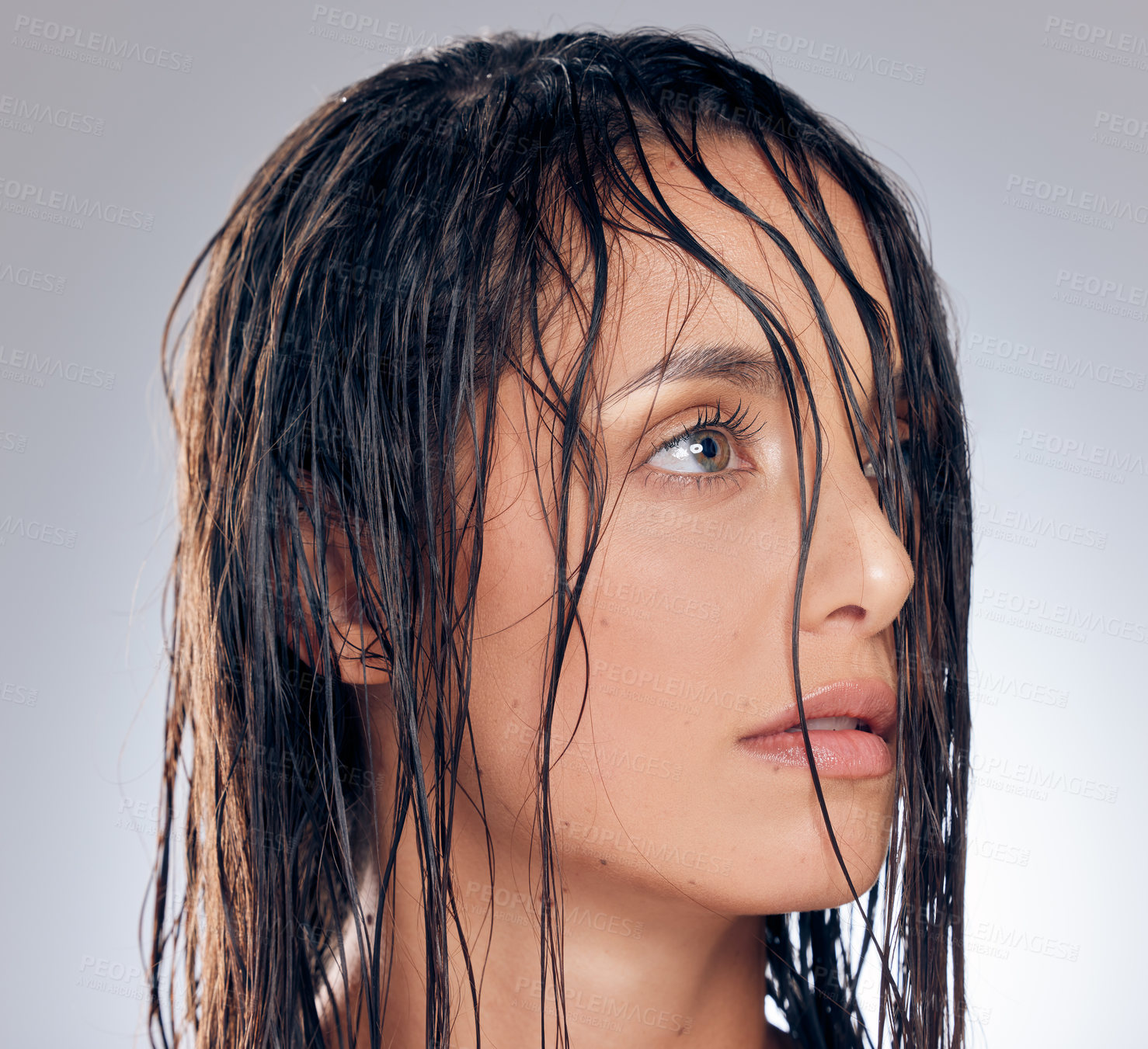 Buy stock photo Shot of an attractive young woman standing alone in the studio and posing with wet hair