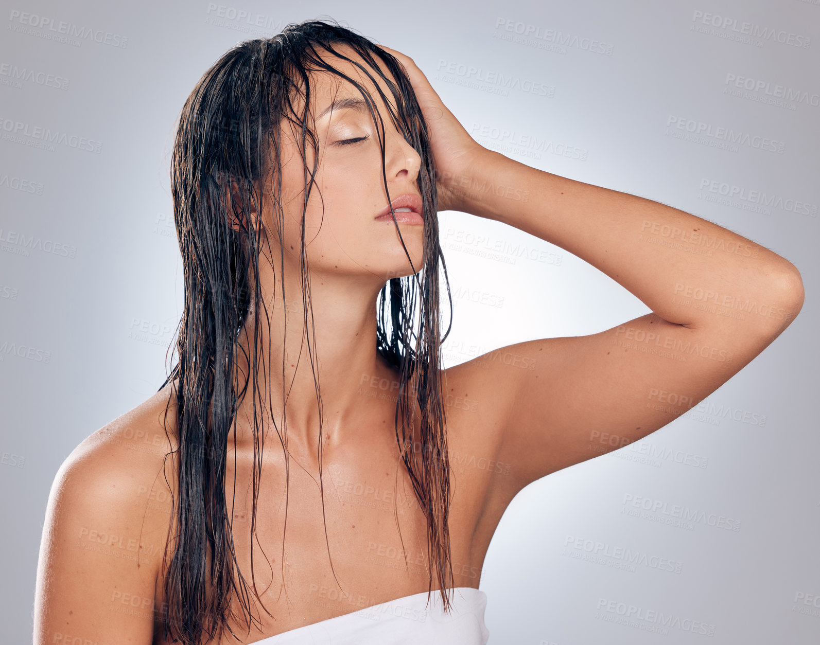 Buy stock photo Shot of an attractive young woman standing alone in the studio and posing with wet hair