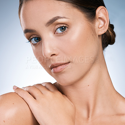 Buy stock photo Closeup portrait of a beautiful young woman posing against a blue background
