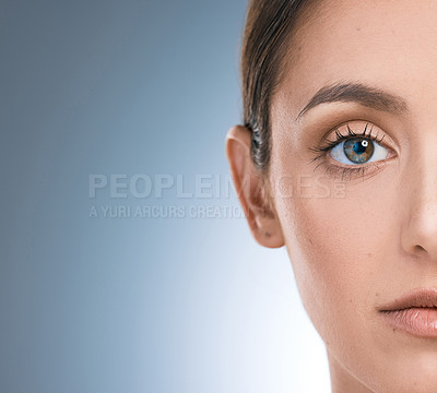 Buy stock photo Woman, half face and skincare in studio, beauty and cosmetics to pamper on blue background. Female person, mockup space and transformation or facial treatment for glow, dermatology and smooth skin