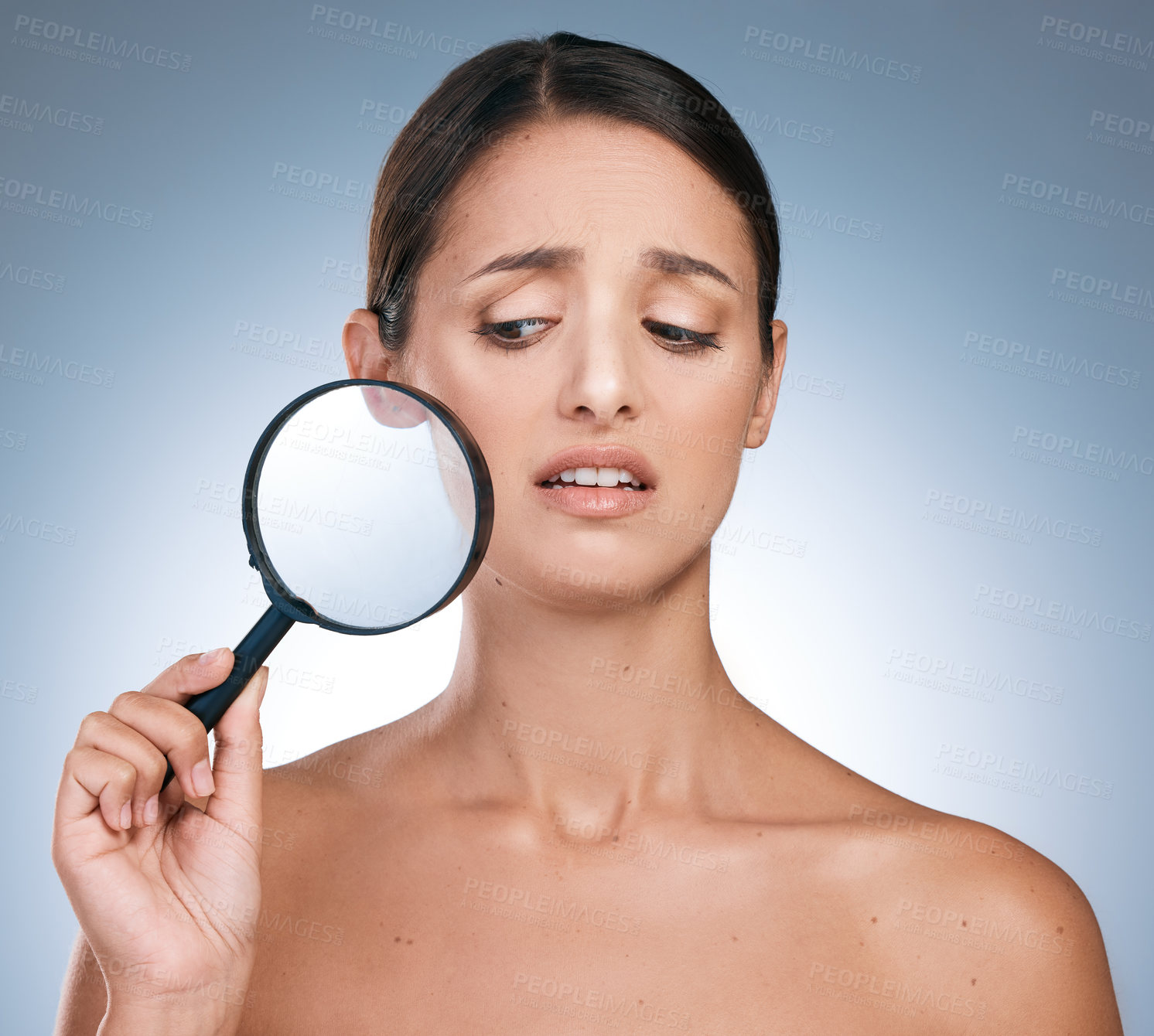 Buy stock photo Woman, surprise and magnify for face skincare or beauty, filler and anti aging on blue background. Cosmetology or spot control for treatment, pamper or dermatology for female person in studio