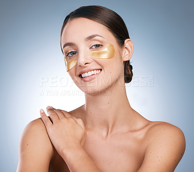 Buy stock photo Portrait of a young attractive woman wearing an under eye patch against a blue background