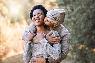 Buy stock photo Shot of a young man kissing his girlfriend during a camping trip