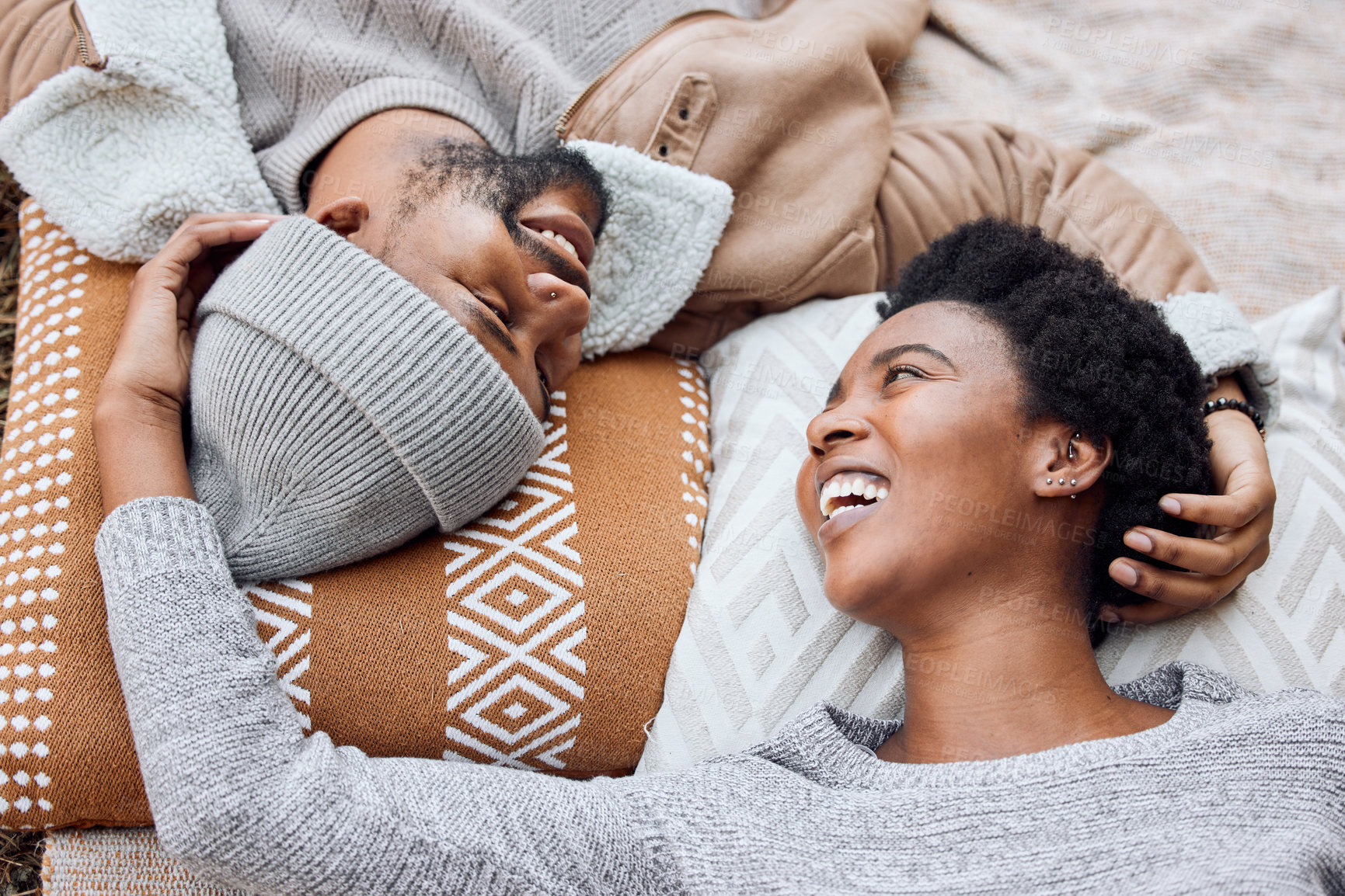 Buy stock photo Black couple, eye contact and happy on bed with care, relax and upside down with love, bonding and laugh in home. African man, woman and smile on break, holiday and start morning in bedroom at house