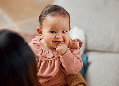Buy stock photo Shot of a woman bonding with her baby while sitting at home