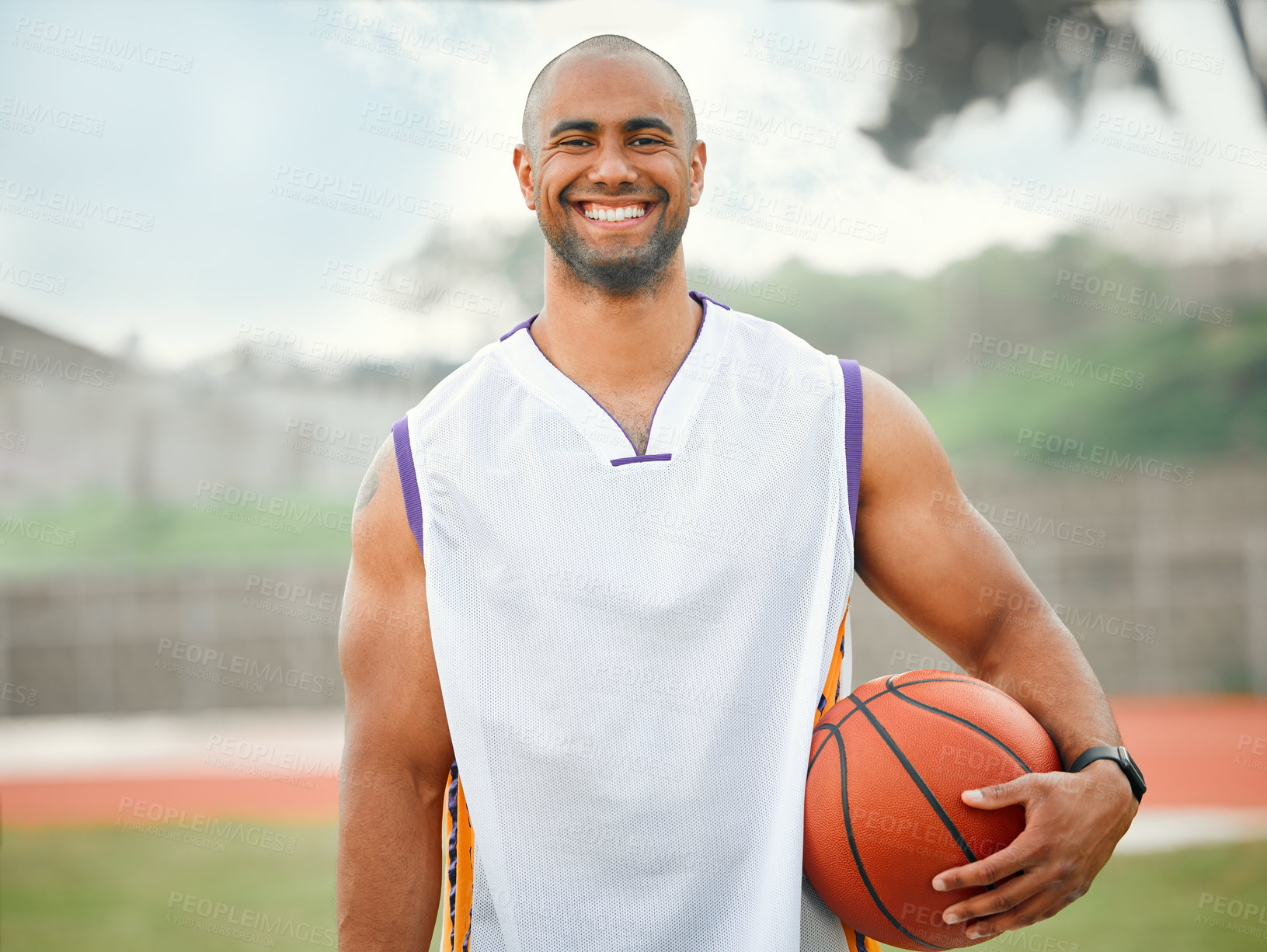 Buy stock photo Cropped portrait of a handsome young male basketball player standing outside with a basketball in hand