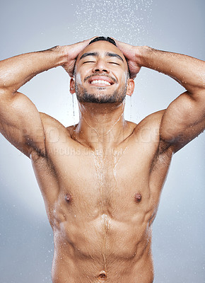 Buy stock photo Studio shot of a handsome young man taking a shower against a grey background