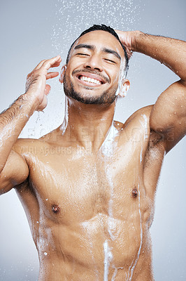 Buy stock photo Studio shot of a handsome young man taking a shower against a grey background