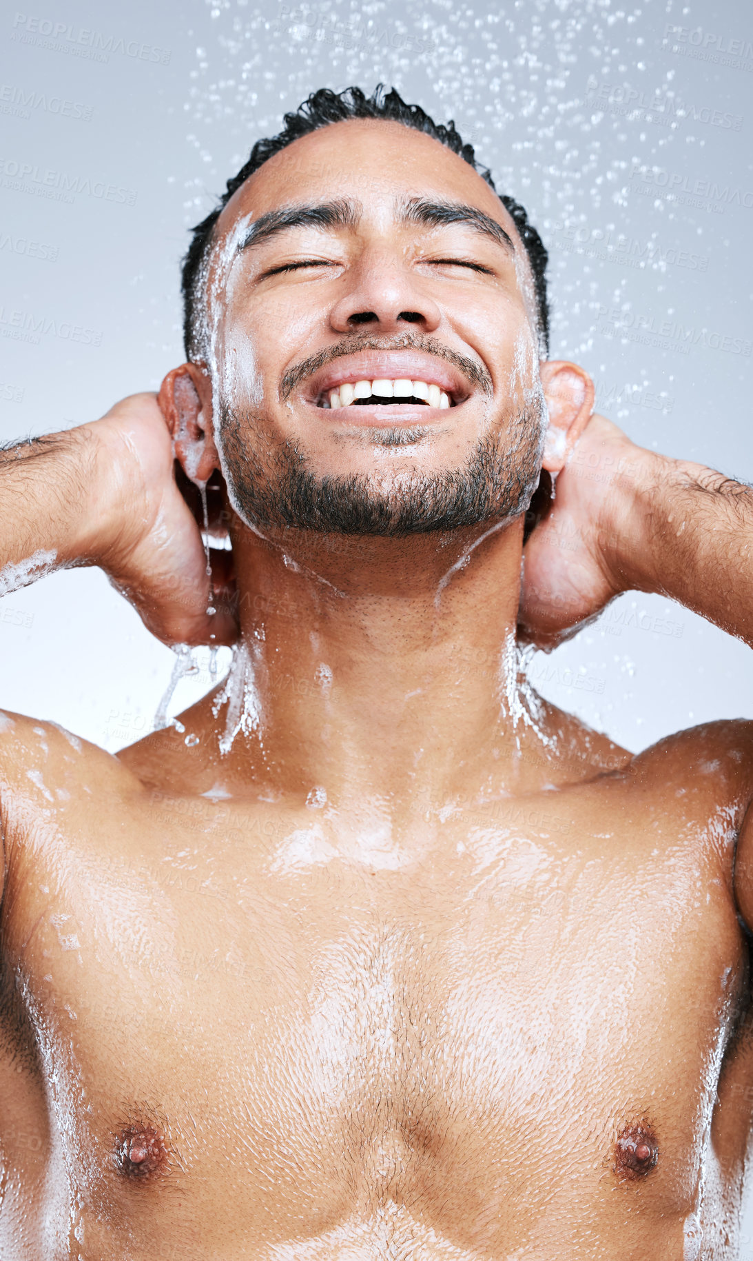 Buy stock photo Studio shot of a handsome young man taking a shower against a grey background