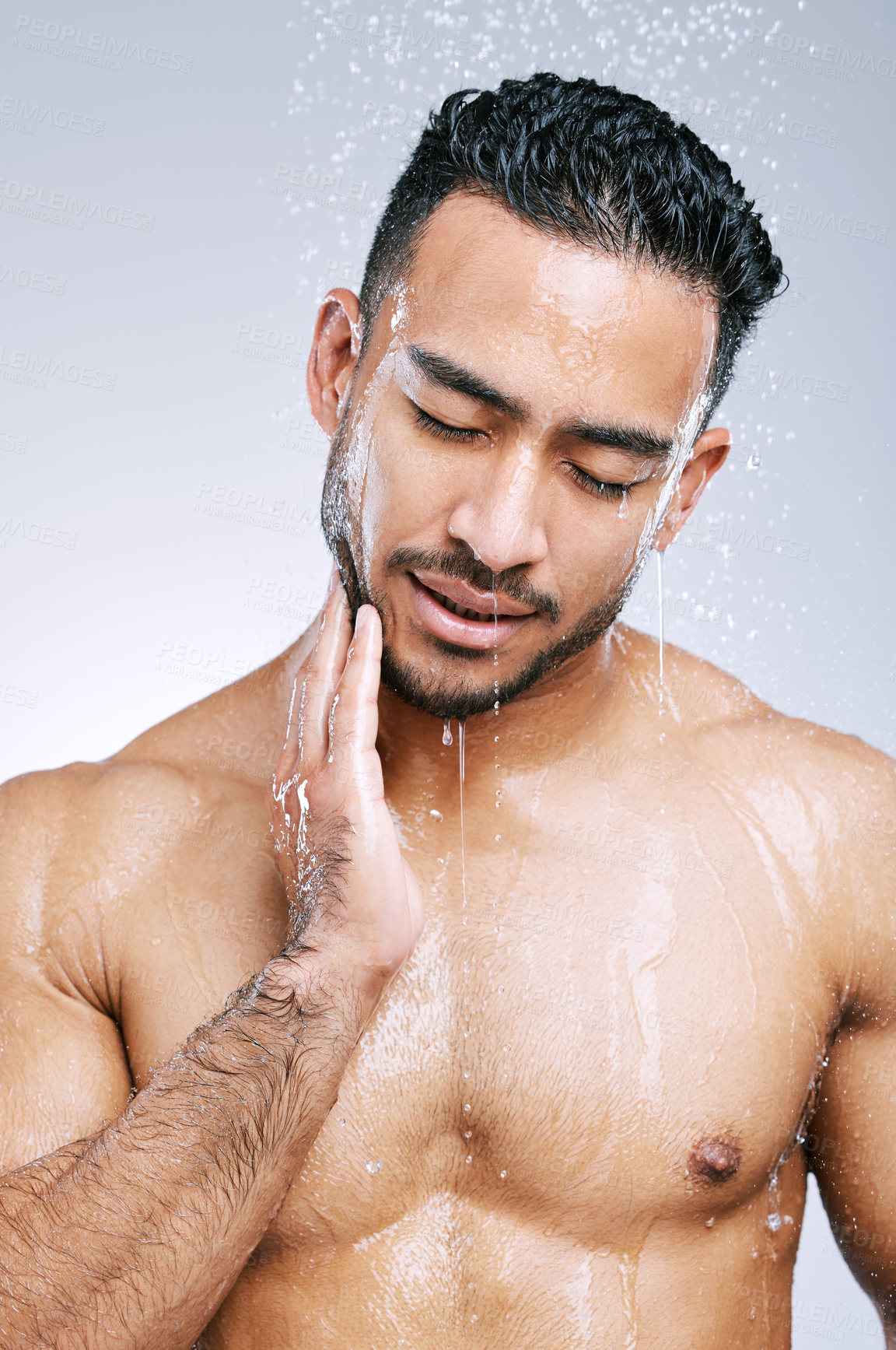 Buy stock photo Shower, man and water on body for cleaning, skincare and wash on white studio background with smile. Male model, happiness and hygiene with clear liquid for facial, wellness and self care in bathroom