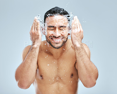 Buy stock photo Studio shot of a handsome young man washing his face against a grey background