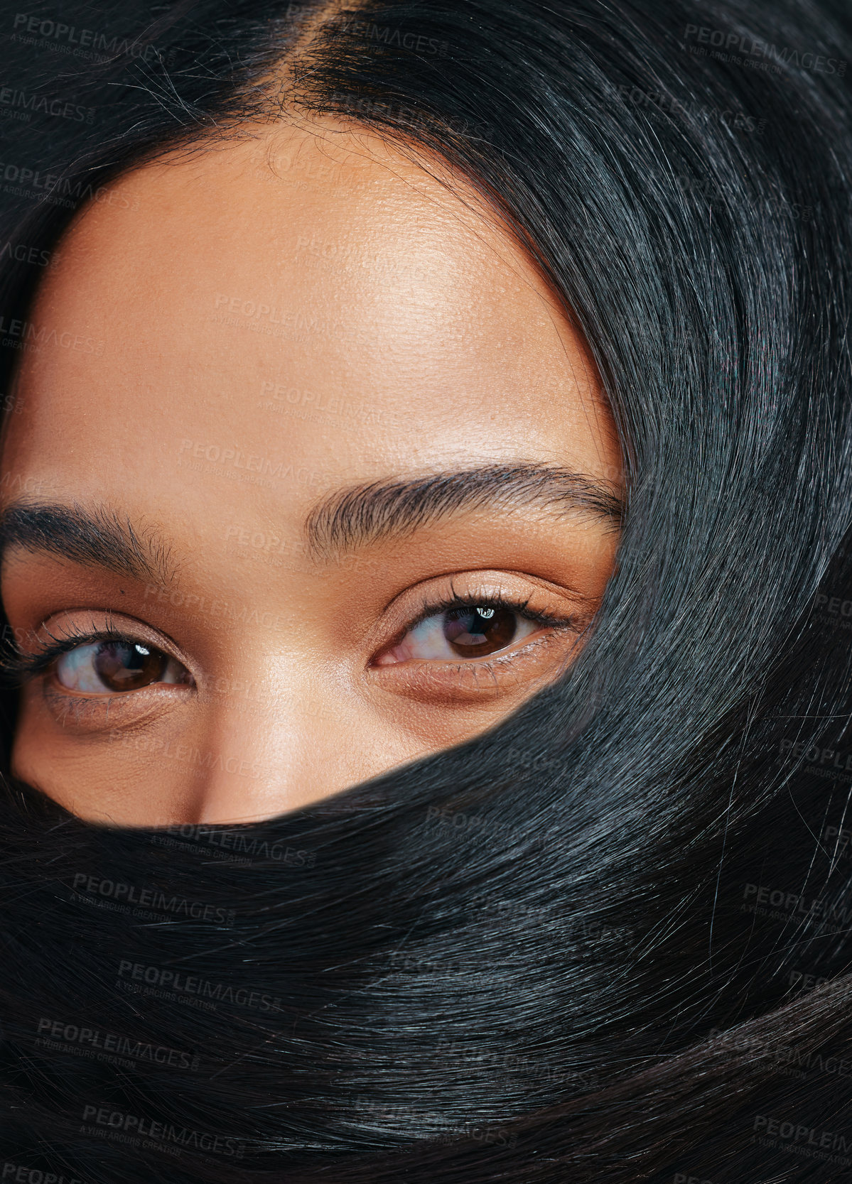 Buy stock photo Studio portrait of an attractive young woman posing with her hair covering her face