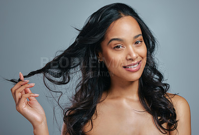 Buy stock photo Studio portrait of an attractive young woman posing against a grey background