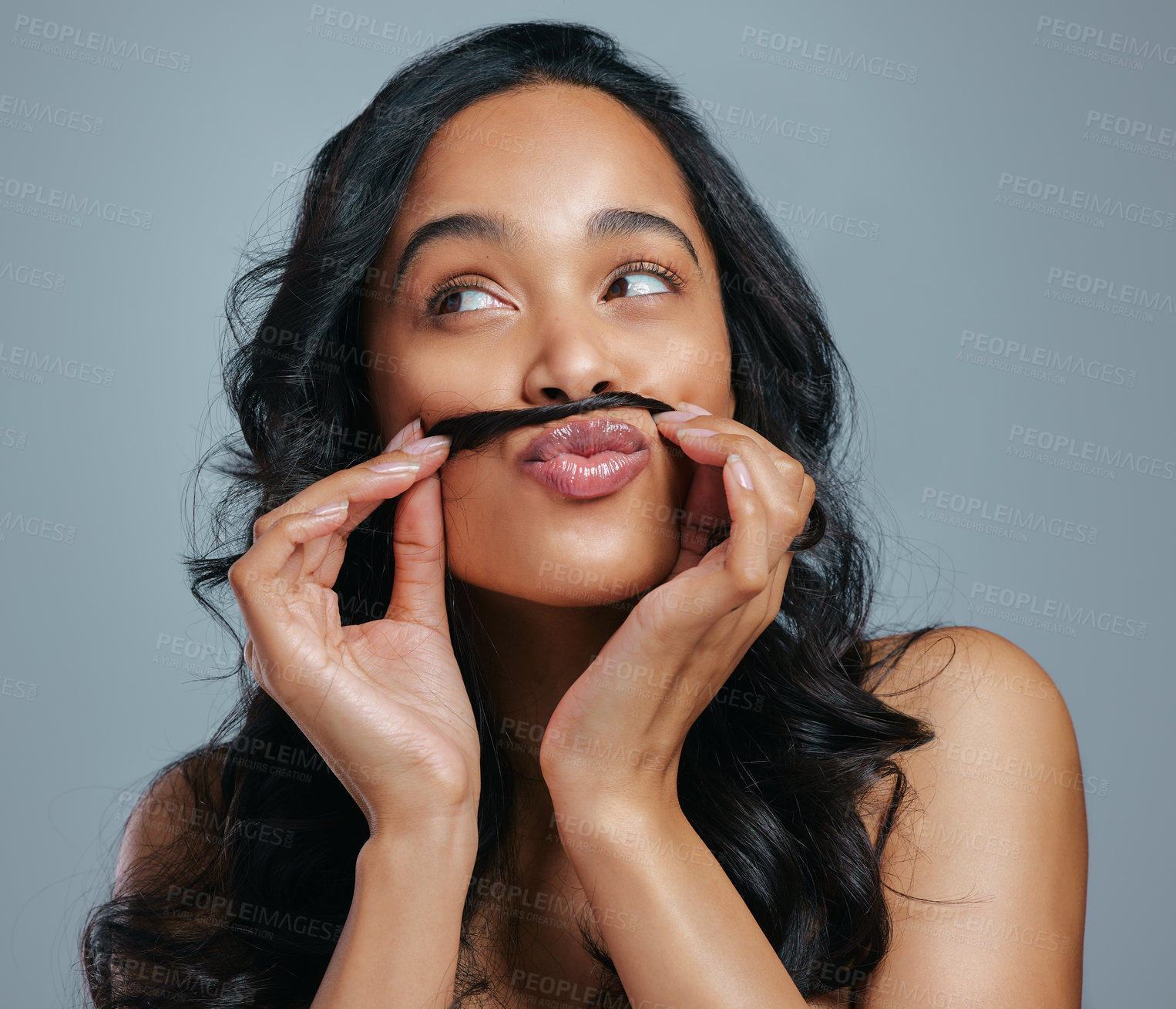 Buy stock photo Studio shot of an attractive young woman making a moustache with her hair against a grey background