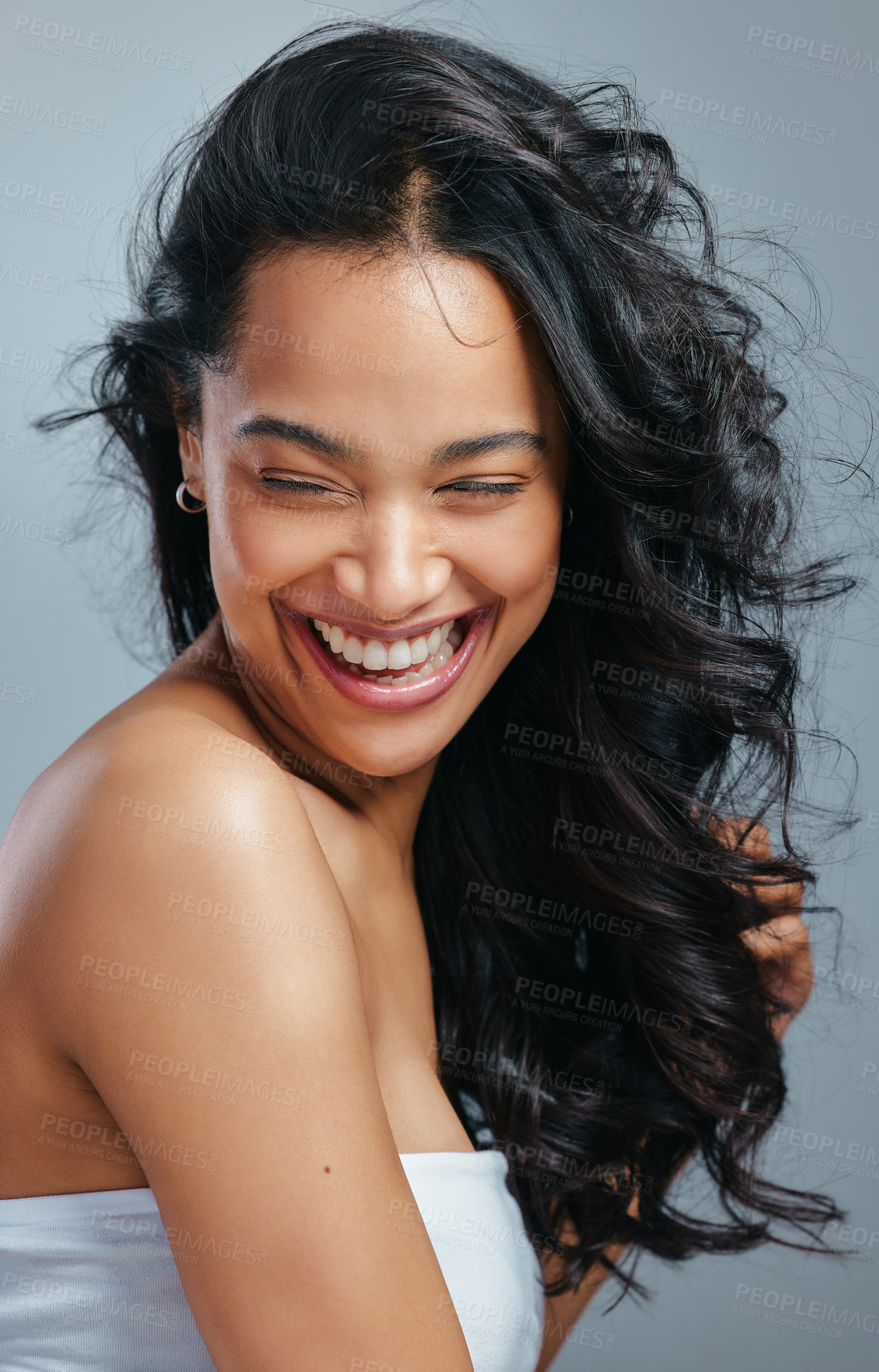 Buy stock photo Studio shot of an attractive young woman posing with wet hair against a grey background