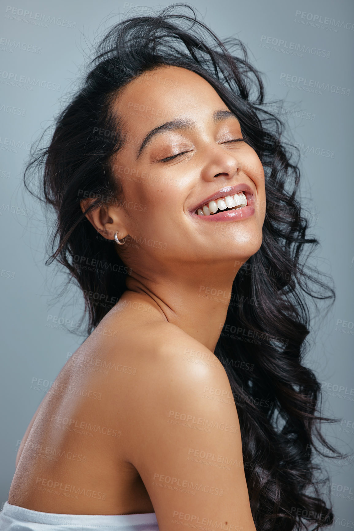 Buy stock photo Hair care, thinking and happy woman in studio with wind, cosmetics and beauty or pride. Smile, model girl and keratin treatment, breeze and glow or shine by grey background for shampoo or conditioner