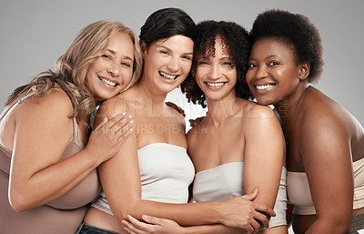 Buy stock photo Shot of a diverse group of women standing and hugging each other in the studio