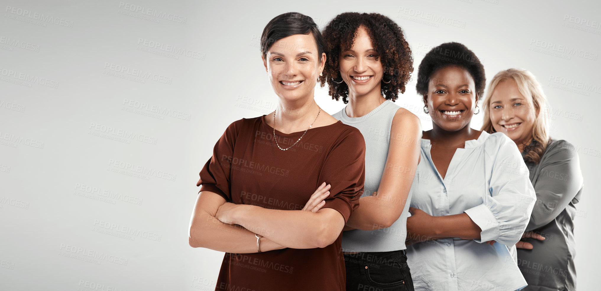 Buy stock photo Shot of a diverse group of women standing together in the studio with their arms folded