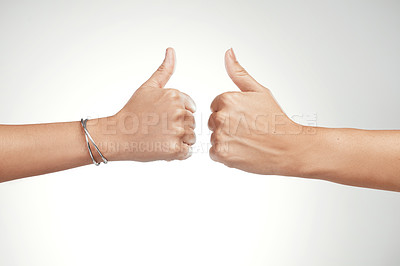 Buy stock photo Cropped shot of two unrecognizable women showing a thumbs up in the studio