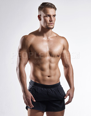 Buy stock photo Shot of a muscular young man posing against a white background