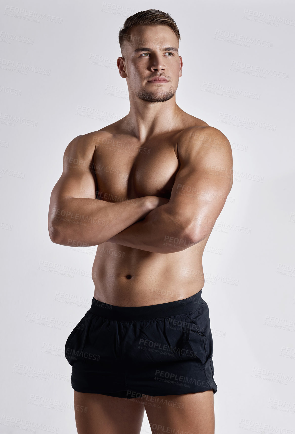 Buy stock photo Shot of a muscular young man posing against a white background