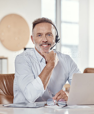 Buy stock photo Shot of a mature man using a headset and laptop in a modern office