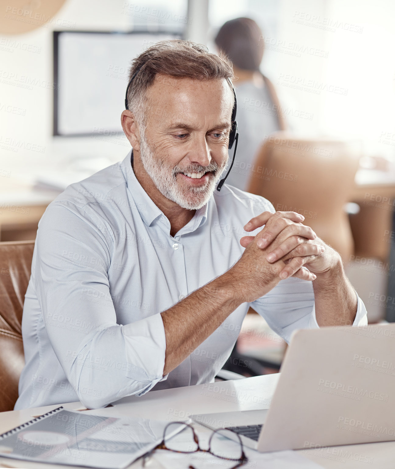 Buy stock photo Shot of a mature man using a headset and laptop in a modern office