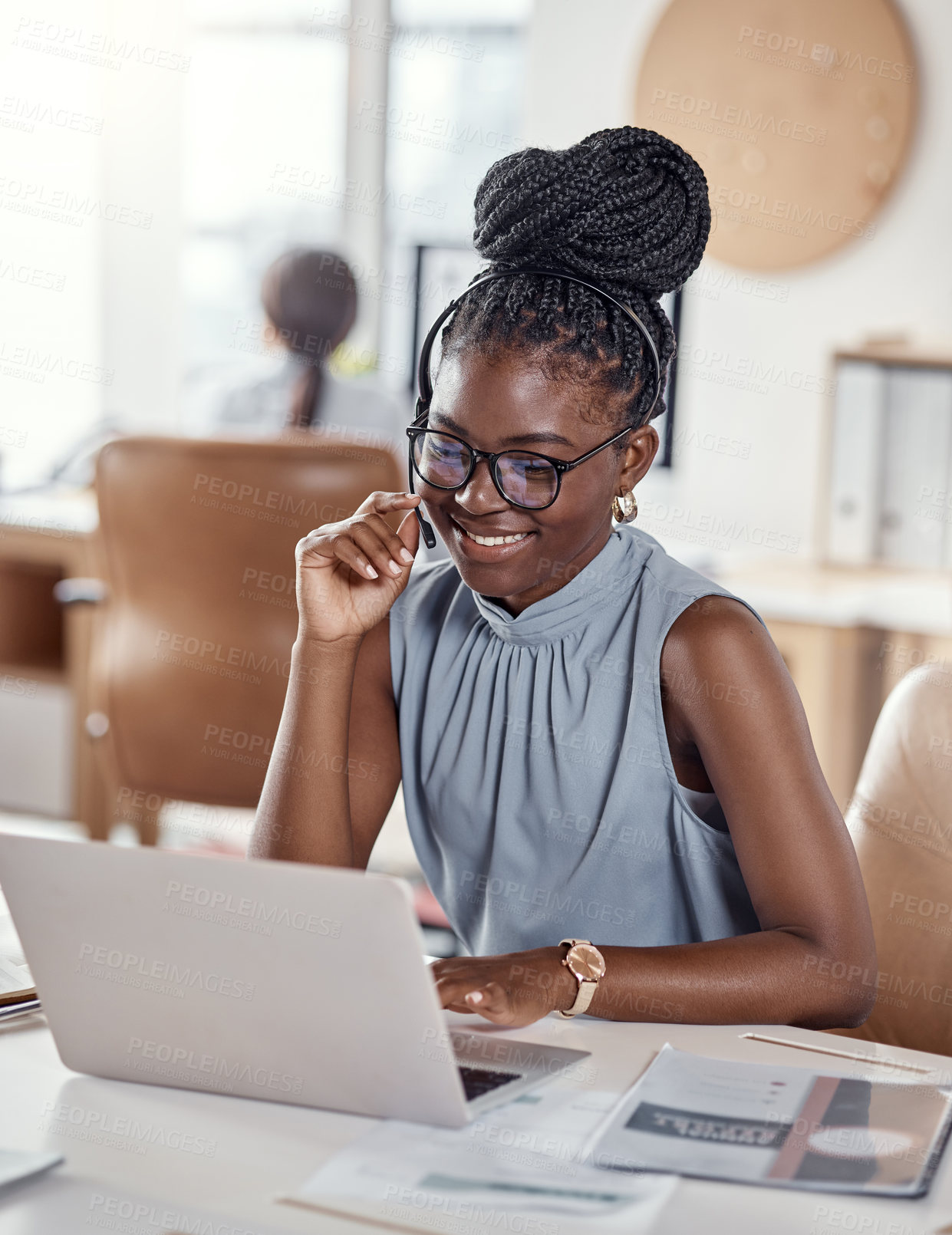 Buy stock photo Shot of a young woman using a headset and laptop in a modern office