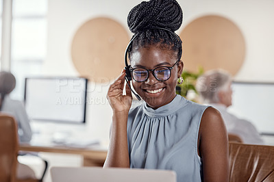 Buy stock photo Shot of a young woman using a headset and laptop in a modern office